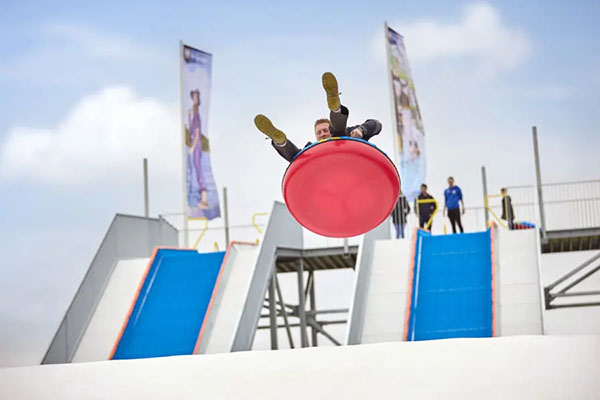 Man flies through the air on the TubbyJump at Terspegelt holiday park