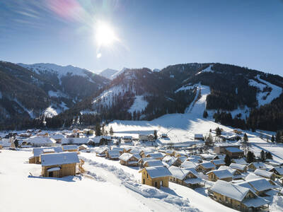 Aerial photo of Alps Resorts Almdorf Hohentauern and ski slopes taken in winter