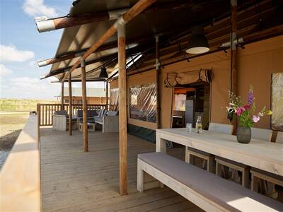 Veranda with picnic table of a glamping tent at the Dutchen Erfgoedpark de Hoop holiday park