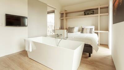 Bedroom with bath in a holiday home at Dutchen Villapark Suitelodges Gooilanden
