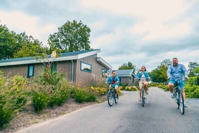 The family cycles between holiday homes at the EuroParcs Zuiderzee holiday park