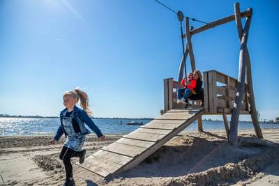 Children in a playground on the beach at Lake Veluwe at holiday park EuroParcs Zuiderzee