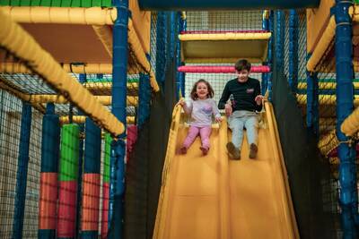 Two children on the slide of the indoor playground at the Europarcs de Achterhoek holiday park