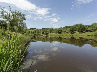 Recreational pond at Landal Wirfttal holiday park with holiday homes in the background