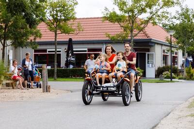 People on a large family bicycle at holiday park RCN Toppershoedje