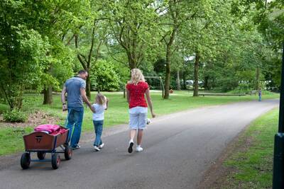 Family with a handcart walks through the Roompot Klein Vink holiday park