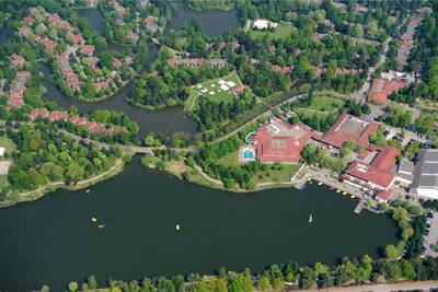 Aerial view of holiday homes and the recreational lake of Roompot Vakantiepark Weerterbergen