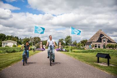 People are cycling at the entrance of the Topparken Park Westerkogge holiday park