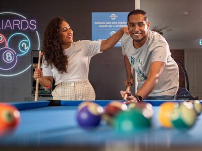 People playing pool in the game room of Topparken Recreatiepark het Esmeer