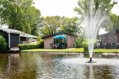 Lodges on a pond with a fountain at the Topparken Résidence De Leuvert holiday park
