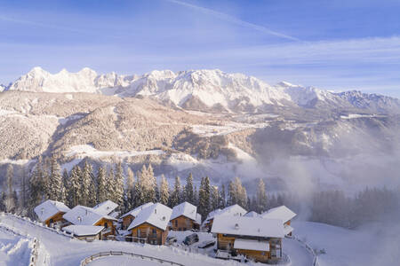 Aerial view of Alps Resorts Alpenchalets Reiteralm in the snow