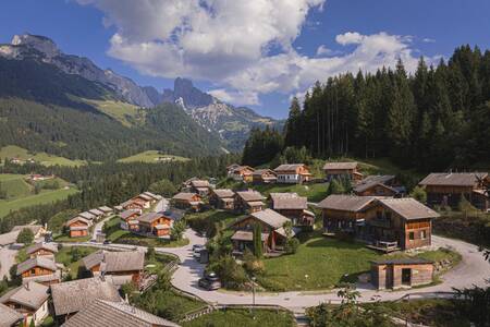 Aerial view of chalets at Alps Resorts Alpendorf Dachstein West, with mountains behind