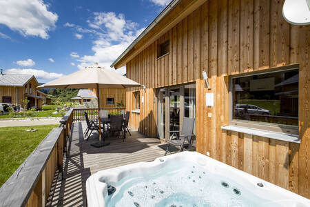 Garden furniture and whirlpool on the terrace of a holiday home at Alps Resorts Feriendorf Murau