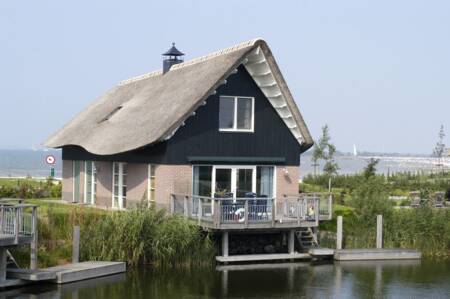 Luxury villa with terrace above the water at the Beach Resort Makkum holiday park
