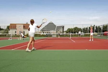 People playing tennis on the tennis court at the Beach Resort Makkum holiday park
