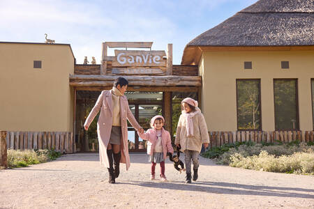 Family walks out of Ganvie Village at the Lake Resort Beekse Bergen holiday park