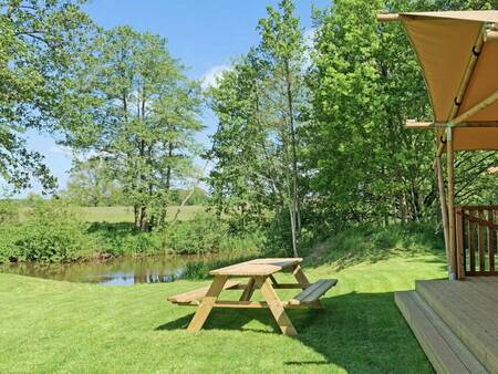 A picnic table in the garden of a glamping Lodge at holiday park Beerze Bulten