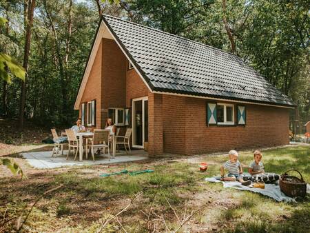 Family in the garden of a detached holiday home at holiday park Beerze Bulten