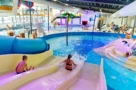 Children slide down the slide in the indoor pool of holiday park Beerze Bulten