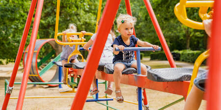 Children on the family swing in a playground at holiday park BreeBronne