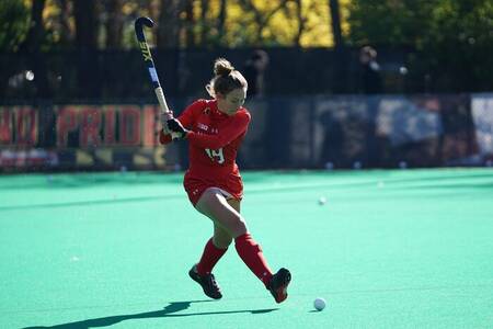 Woman playing hockey on the hockey field at holiday park Brinckerduyn