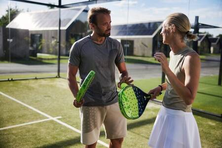 Couple plays a game of padel, a combination of squash and tennis at holiday park Brinckerduyn
