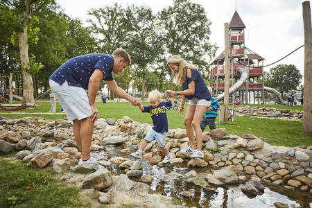 Children playing at the play river in the playground at Buitenhof de Leistert