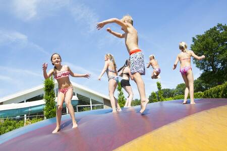 Children jump on the air trampoline in a playground at the Camping de Noetselerberg holiday park