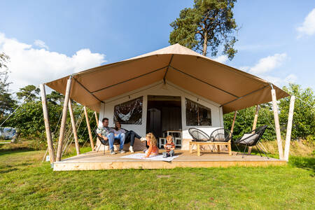 People under the awning of a safari tent at the Camping de Norgerberg holiday park