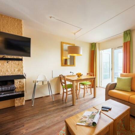 Living room with fireplace of a holiday home at Center Parcs Port Zélande