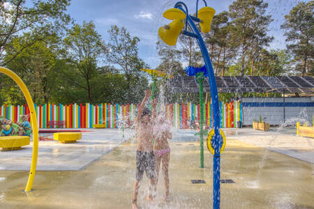 Children play in the water playground of camping site De Berenkuil