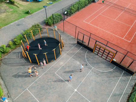 Children play in the panna cage and on the football field at holiday park De Boshoek
