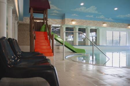 Slide and sun loungers in the indoor pool of holiday park De Boshoek