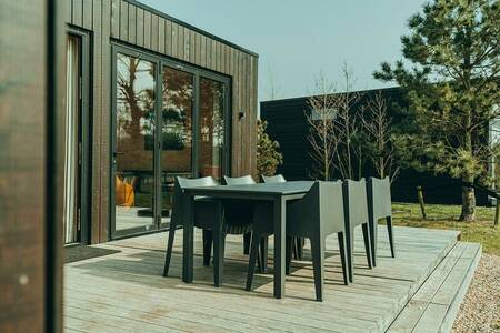 Terrace with garden chairs of a holiday home at holiday park De Klepperstee