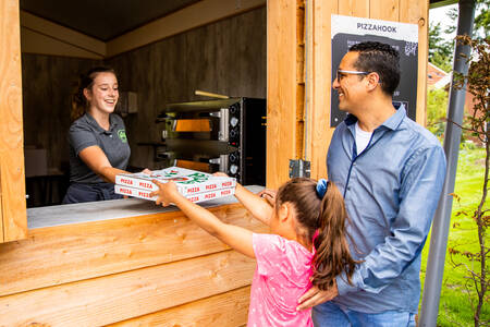 Father and daughter buy pizzas at the Pizzahook on camping site De Witte Berg