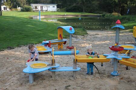 Children play in the water playground at De Witte Berg campsite
