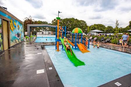 Children on play equipment in the covered outdoor swimming pool at De Witte Berg