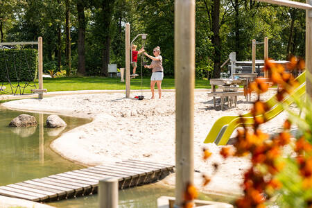Mother and child playing in the water playground at De Witte Berg