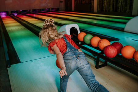 Girl bowling on the bowling alley of the Dierenbos holiday park