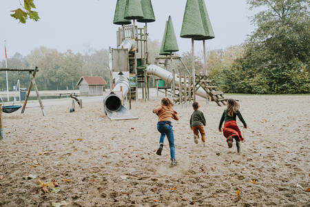 Children run to a large climbing frame in a playground at the Dierenbos holiday park