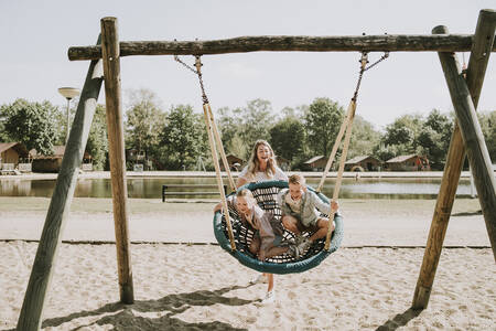 Children on a large swing in a playground at the Dierenbos holiday park