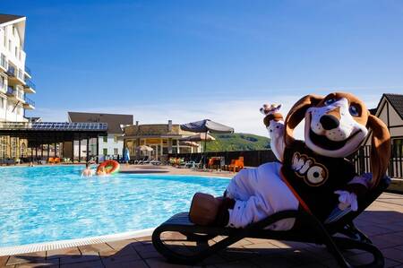 Mio mascot on a lounger by the outdoor pool of the Dormio Eifeler Tor holiday park
