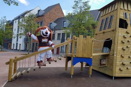 Mio, the mascot of Dormio Resort Maastricht in a playground