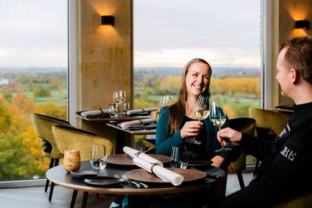 Man and woman in the panorama restaurant "Rantrée" at holiday park Dormio Resort Maastricht