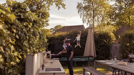 Children jump on a trampoline in the garden of a villa at the Dutchen Park Duynvoet holiday park