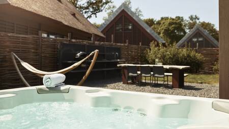 Whirlpool, hammock and dining table in the garden of a holiday villa at the Dutchen Park Duynvoet