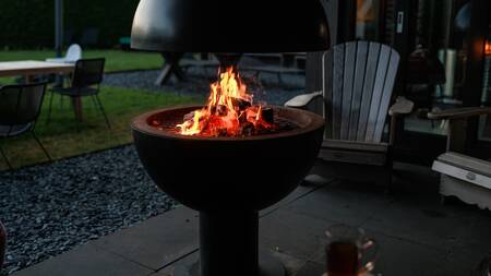 Outdoor fireplace in the garden of a luxury villa at the Dutchen Park Duynvoet holiday park