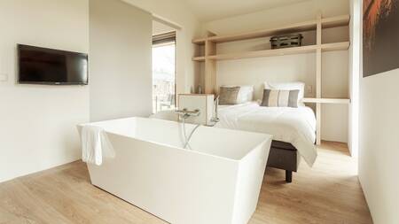 Bedroom with bath in a holiday home at Dutchen Villapark Suitelodges Gooilanden