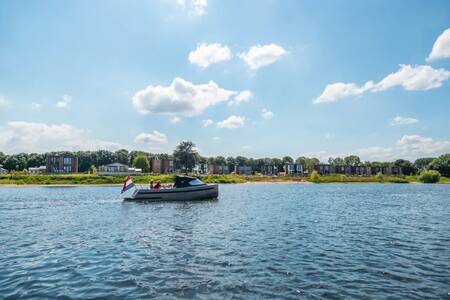 Boat sails across the lake next to the EuroParcs Aan de Maas holiday park