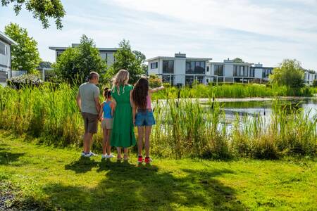 The family looks across the water at holiday homes at the EuroParcs Bad Hulckesteijn holiday park